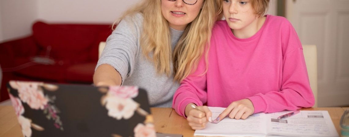 Mother and daugther learning together via laptop.